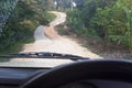 Road through jungle, view behind windshield of car. Dangerous upward climb Royalty Free Stock Photo