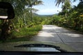 Road through jungle, view behind windshield of car Royalty Free Stock Photo