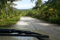 Road through jungle, view behind windshield of car Royalty Free Stock Photo