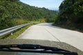 Road through jungle, view behind windshield of car Royalty Free Stock Photo