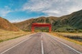 Road in the lands of Tuva under a beautiful traditional steppe Asian arch