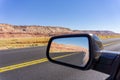 Road and landscape in rear vision mirror through Arizona