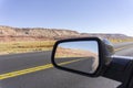 Road and landscape in rear vision mirror through Arizona.