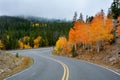 Road leading to autumn forest and mountains covered with fog Royalty Free Stock Photo