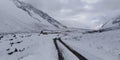 Road leading to cold hell in the mountains snowy close to clouds