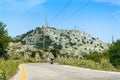 Road leading to the rocky highest peak Pantokrator, young people ride a motorbike