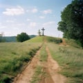 The road leads into the distance, at the end of the road there is a grave cross, the concept of finiteness