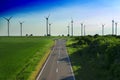 road leads to wind turbines producing alternative energy Royalty Free Stock Photo