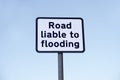 Road liable to flooding sign post against blue sky Royalty Free Stock Photo