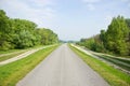 Road Lined by Trees and Small Bypaths Royalty Free Stock Photo