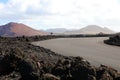 Road in lunar landscape of Lanzarote with red volcanic mountains on the background, Canary Islands Royalty Free Stock Photo