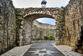 A road made of white and black tiles between the stone walls Royalty Free Stock Photo