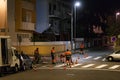 Road maintenance service workers painting zebra at night