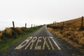 Road marking with the word Brexit painted on remote road a misty day. Concept uncertainty and solitude