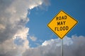 Road May Flood Sign Against A Blue Sky and Storm clouds.