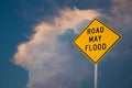 Road May Flood Sign Against A Blue Sky and Storm clouds.