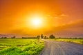 Road on meadow with beautiful sunset sky Royalty Free Stock Photo