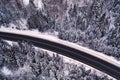 Road in mountain winter forest, drone view