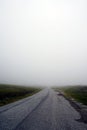 Road in the mountains captured during the fog. Mountainous landscape of Norway.