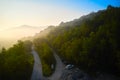 The road in the mountains in the rays of the rising sun. Shooting from a drone.