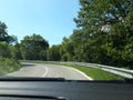 Road in the mountains seen from the windshield of the traveling car.