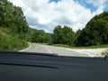 Road in the mountains seen from the windshield of the traveling car.