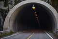 Road in the mountains with a tunnel. The road goes into the tunnel, the markings on the road Royalty Free Stock Photo