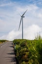 The road near wind propeller turbines. Green energy concept. Royalty Free Stock Photo