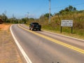 Road with a new traffic sign informing the new law that requires the use of headlights on even during the day on the roads with a Royalty Free Stock Photo