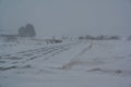 Road over fields covered in blowing snow Royalty Free Stock Photo