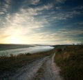 Road over village and hills in morning mist on background of sky Royalty Free Stock Photo