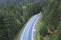 The road passes through a dense forest in the mountains Royalty Free Stock Photo