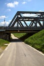 Road that passes under a railway bridge on a clear day in spring in the italian countryside Royalty Free Stock Photo