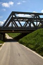 Road that passes under a railway bridge on a clear day in spring in the italian countryside Royalty Free Stock Photo