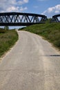 Road that passes under a railway bridge on a clear day in spring in the italian countryside Royalty Free Stock Photo