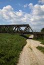 Road that passes under a railway bridge on a clear day in spring in the italian countryside Royalty Free Stock Photo