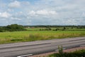Road passing green fields and farns in summer.. Royalty Free Stock Photo
