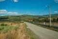 Road passing through hilly landscape with farms