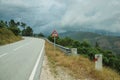 Road passing through hilly landscape and traffic signpost Royalty Free Stock Photo