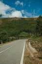 Road passing through hilly landscape with wind turbines Royalty Free Stock Photo