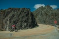 Road passing through rocky landscape with cyclist