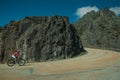 Road passing through rocky landscape with cyclist