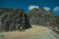 Road passing through rocky landscape with cyclist