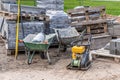 Road and pavement constuction work site with bricks piles, rammer machine and carts. Royalty Free Stock Photo
