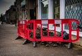 Road pavement excavation work area with red safety barriers