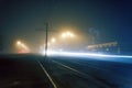 Road with poles with high-voltage wires and tram tracks or tram rails , evening fog on the streets, poles with high-voltage wires Royalty Free Stock Photo