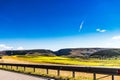 Road with road railing passing near sunflower field with a mountain scenery in the background Royalty Free Stock Photo