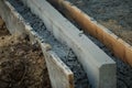 Road repair, installation of curbs. Laying a new border. The end face of a stone filled with concrete mixture close up