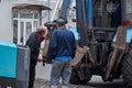 Road repair. Workers repairing an excavator bucket