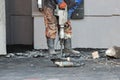 Road repairing works with jackhammer. Male worker using jackhammer pneumatic drill machinery on road repair. Arkhangelsk. Royalty Free Stock Photo